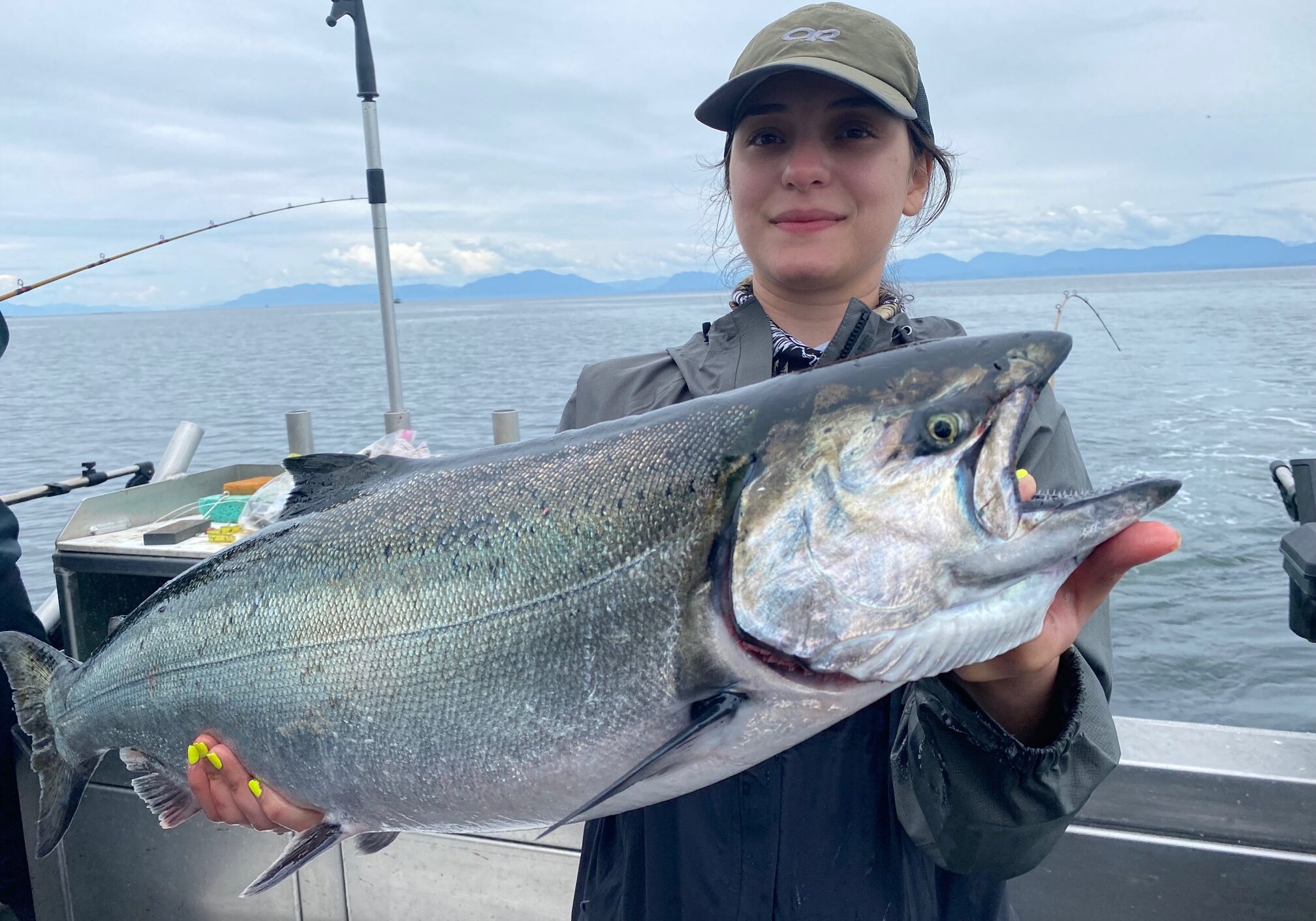Woman holding a silver salmon caught during a Ketchikan fishing charter